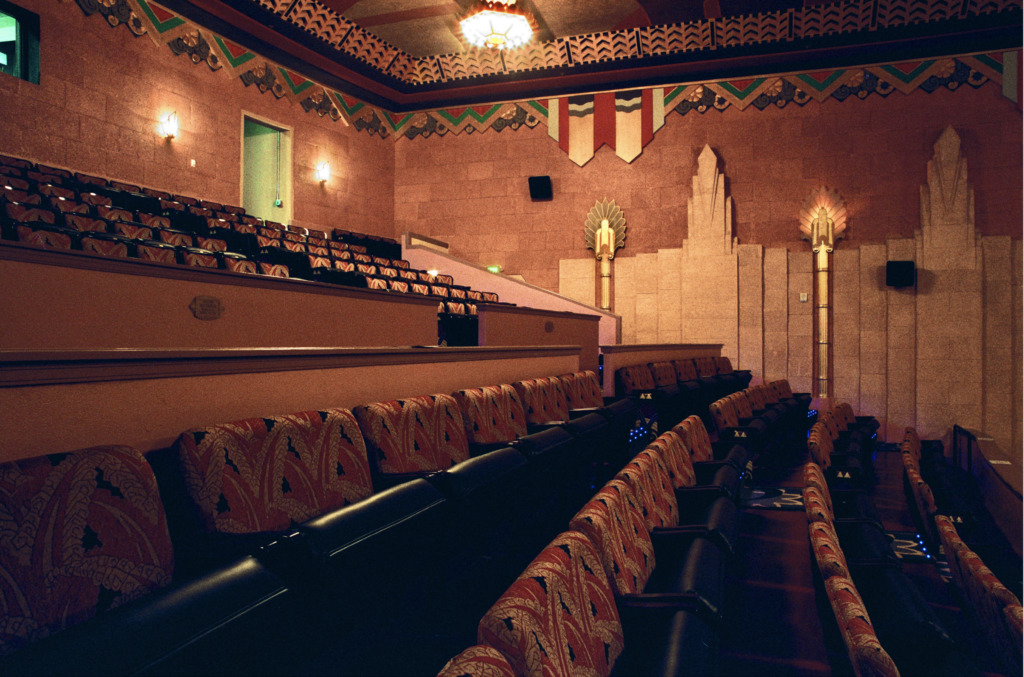 This is a close up of the upper level seats inside the theater. You can see the great amount of historic art and details on the walls, the cloth covered seats.